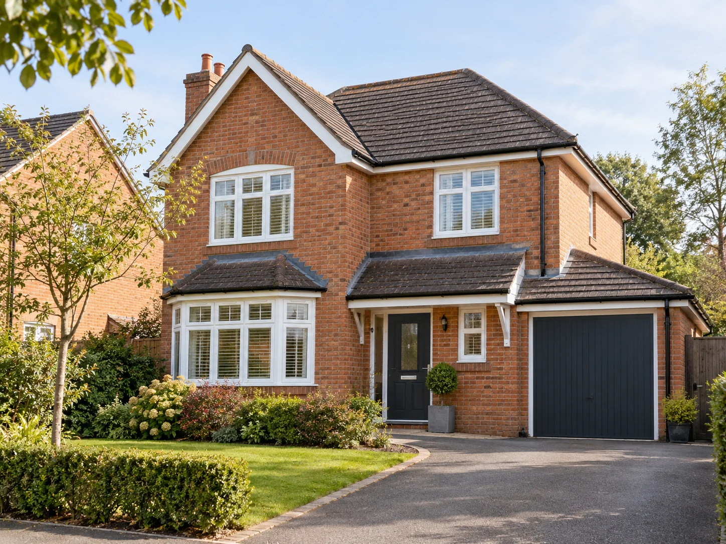 Detached brick family home with a driveway and front garden.